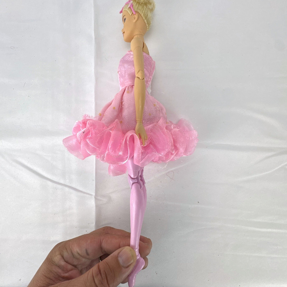 Mattel Barbie 12-inch articulated ballerina doll wearing a pink ruffled tutu dress with blonde bun hair.