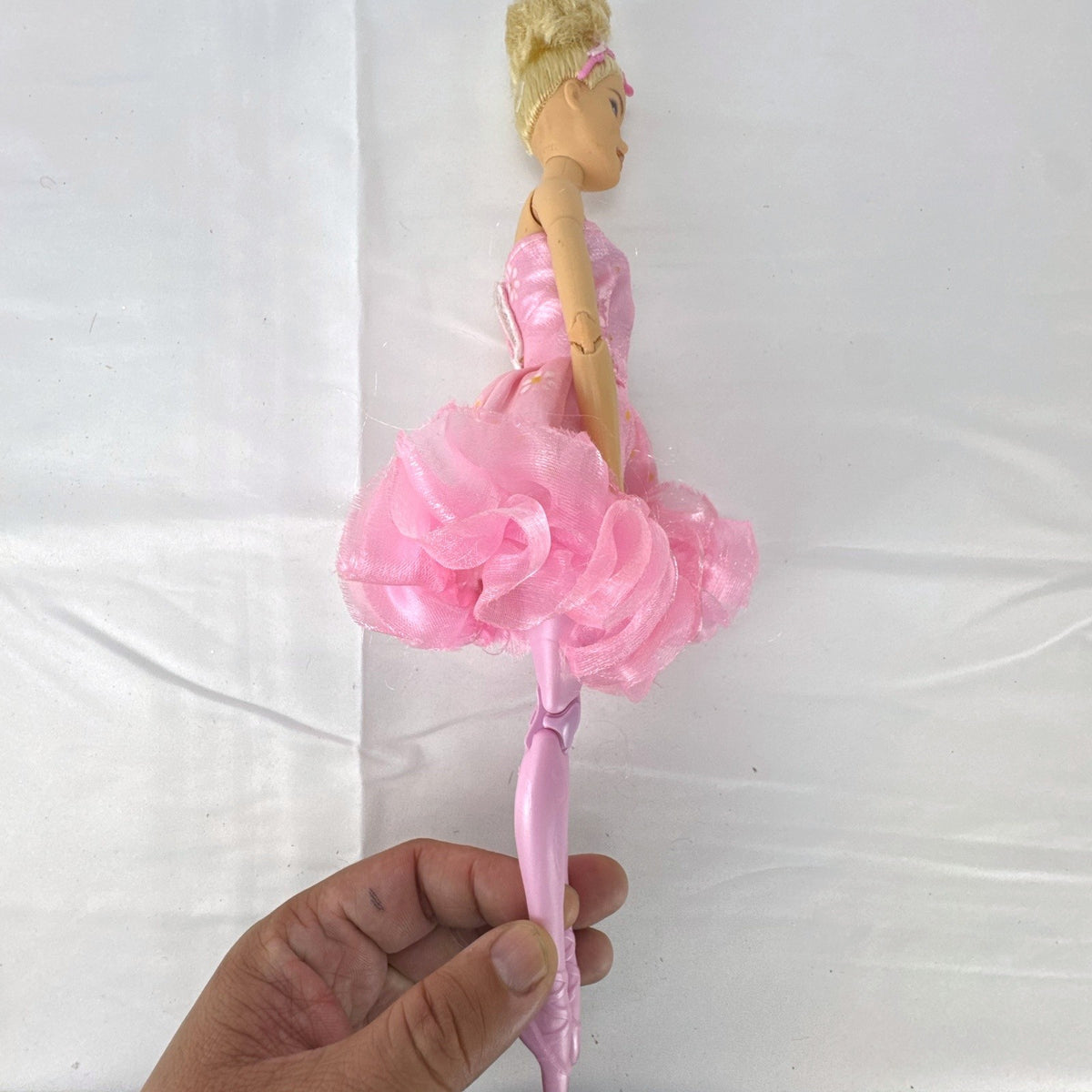 Mattel Barbie 12-inch articulated ballerina doll wearing a pink ruffled tutu dress with blonde bun hair.