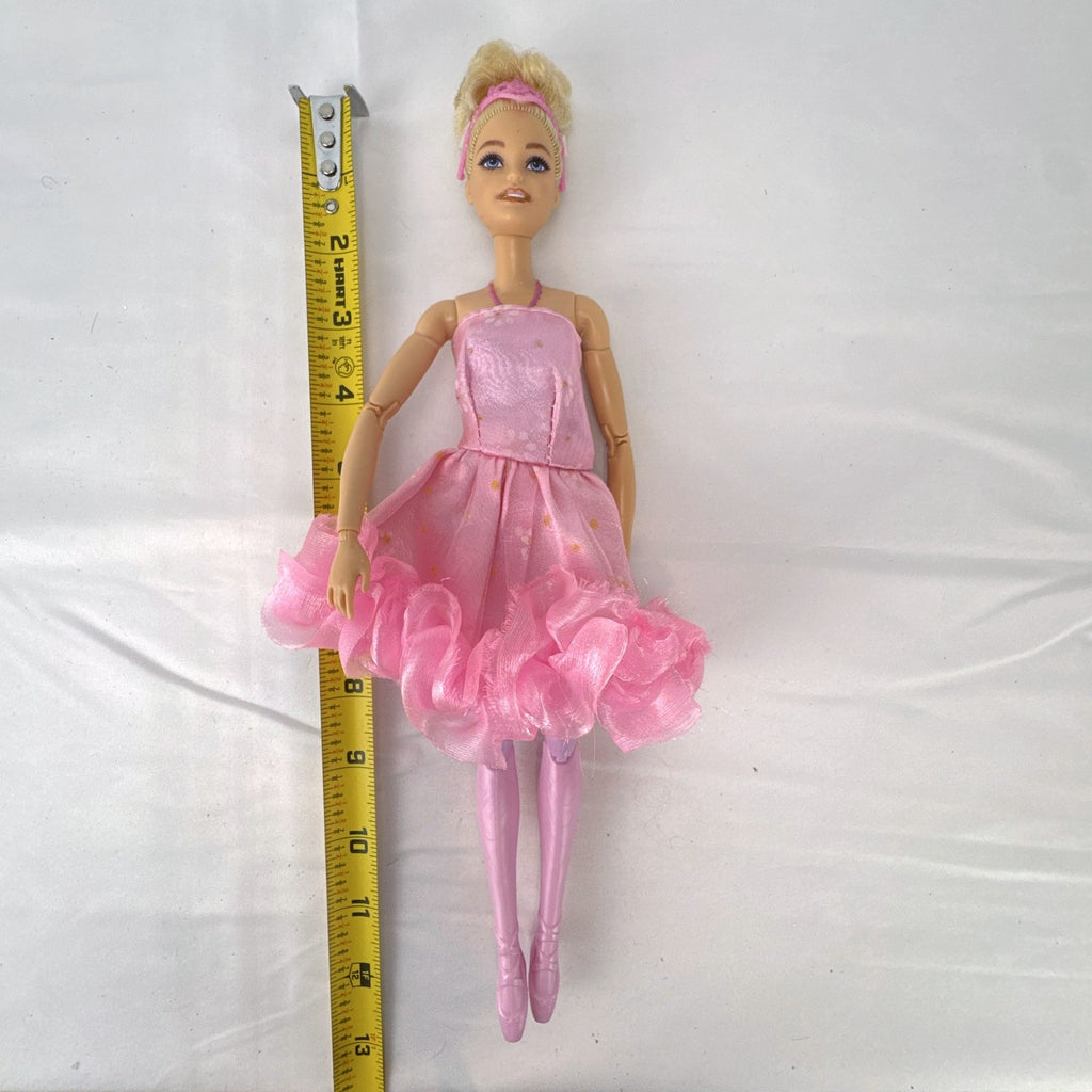 Mattel Barbie 12-inch articulated ballerina doll wearing a pink ruffled tutu dress with blonde bun hair.