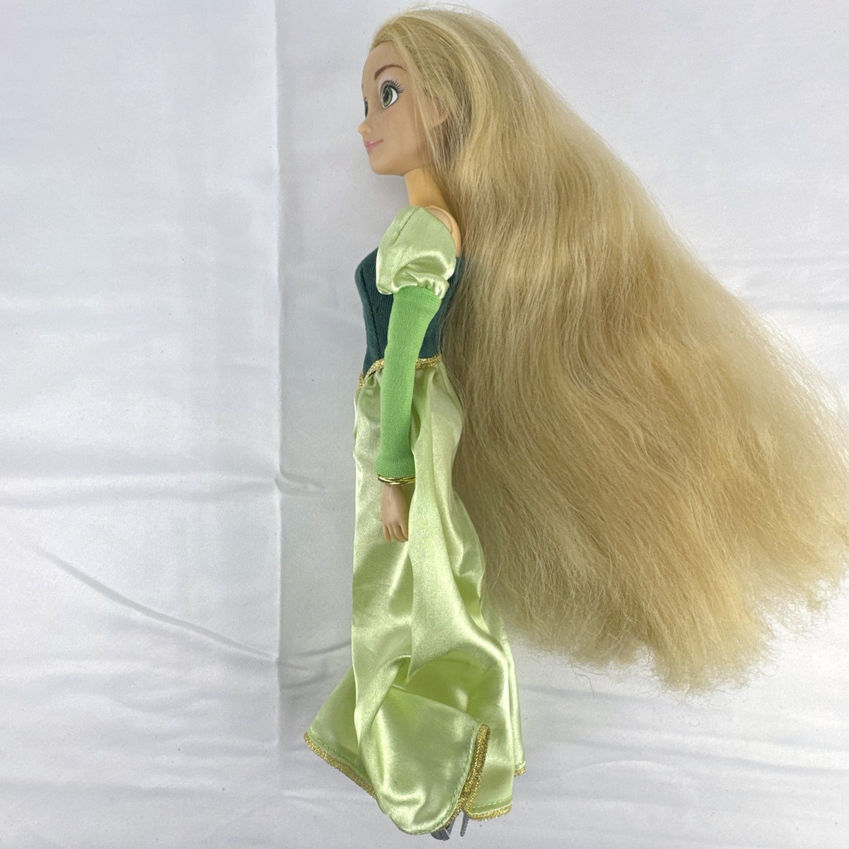 Disney Princess Rapunzel 12-inch fashion doll wearing a two-tone green gown with gold trim and grey shoes.