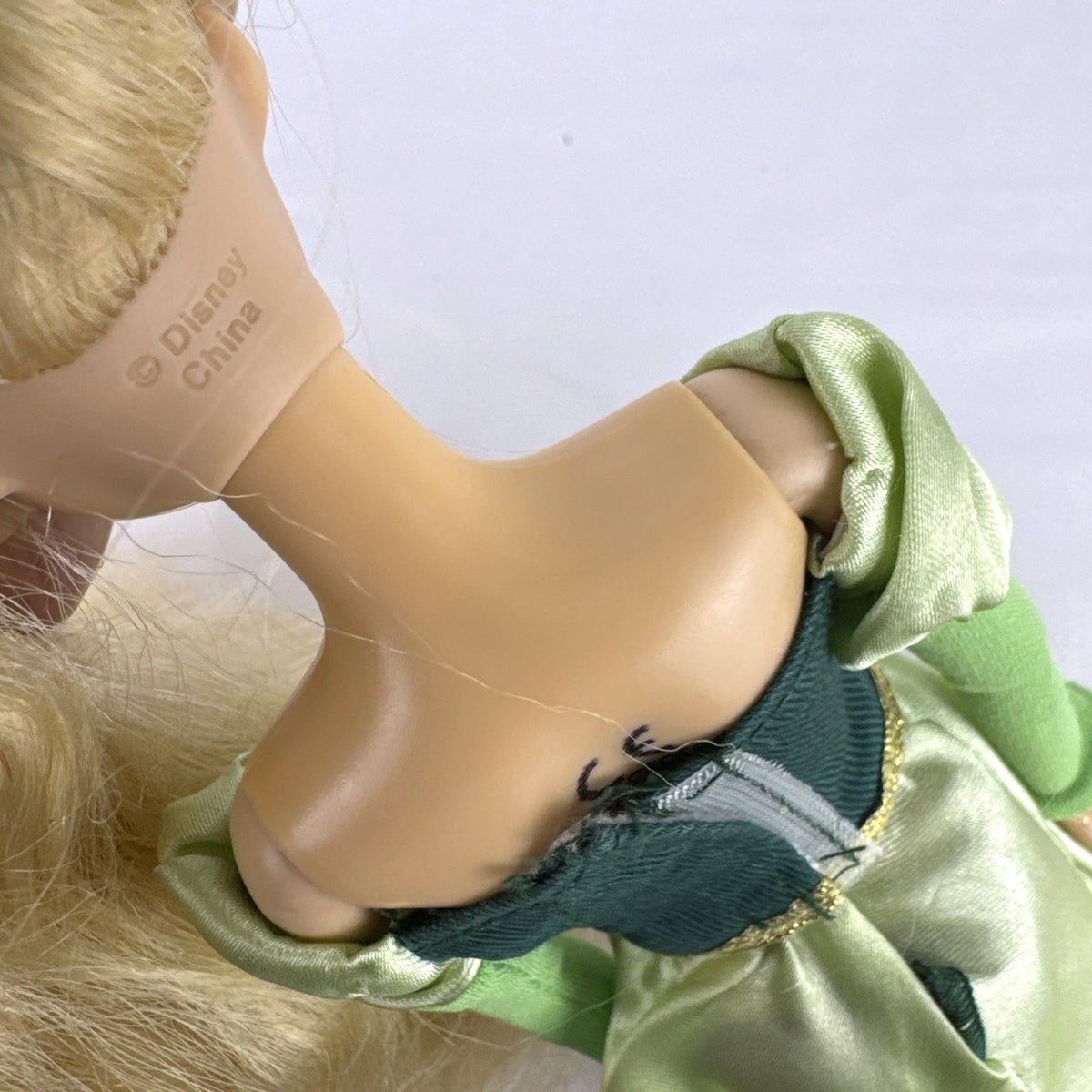 Disney Princess Rapunzel 12-inch fashion doll wearing a two-tone green gown with gold trim and grey shoes.