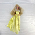 Vintage Mattel Barbie doll wearing yellow butterfly pattern gown with pink earrings