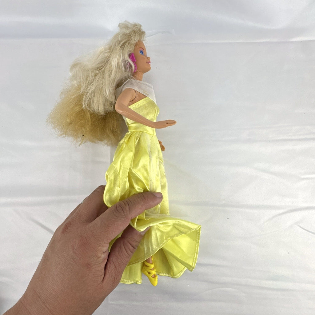Vintage Mattel Barbie doll wearing yellow butterfly pattern gown with pink earrings