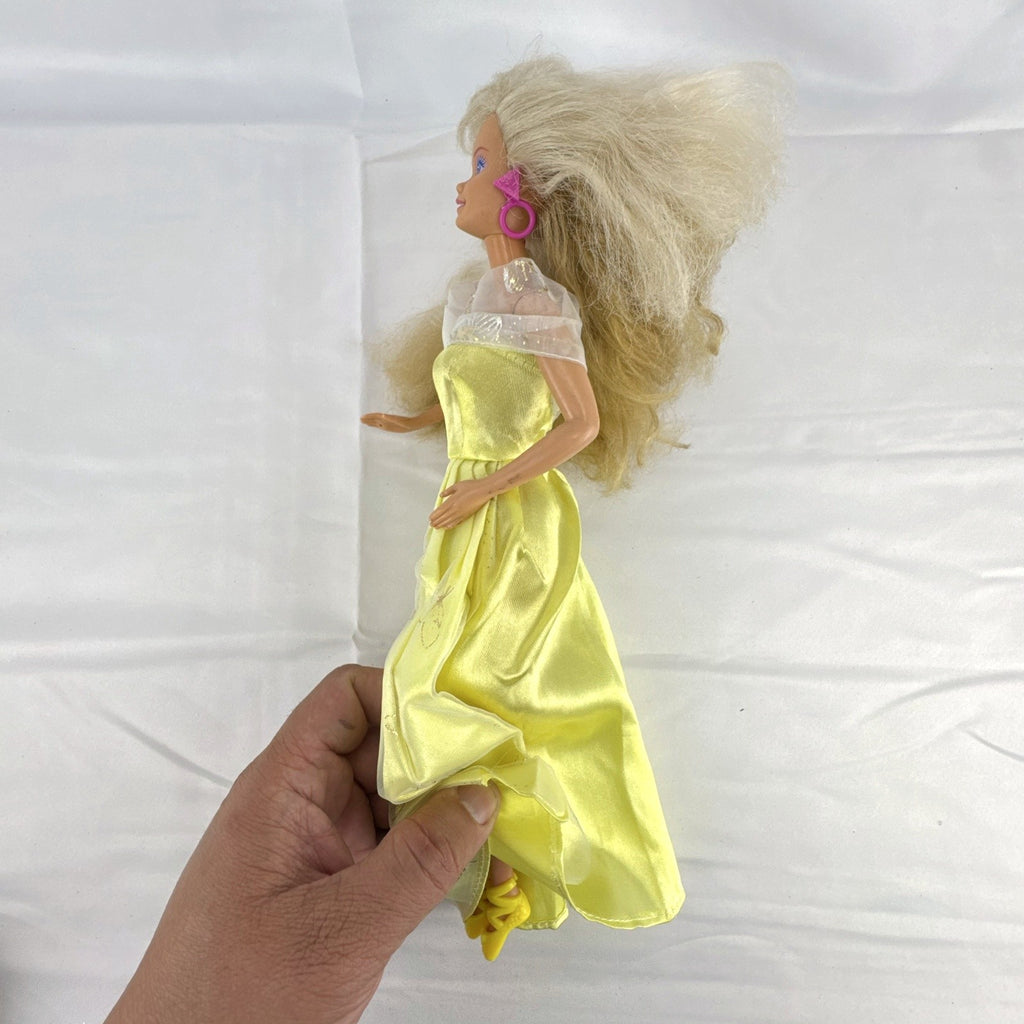 Vintage Mattel Barbie doll wearing yellow butterfly pattern gown with pink earrings