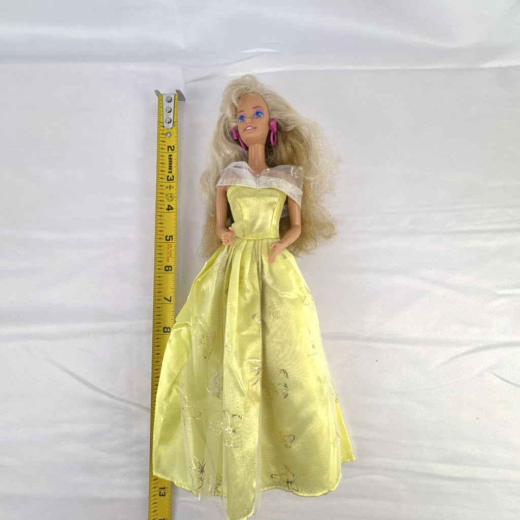 Vintage Mattel Barbie doll wearing yellow butterfly pattern gown with pink earrings