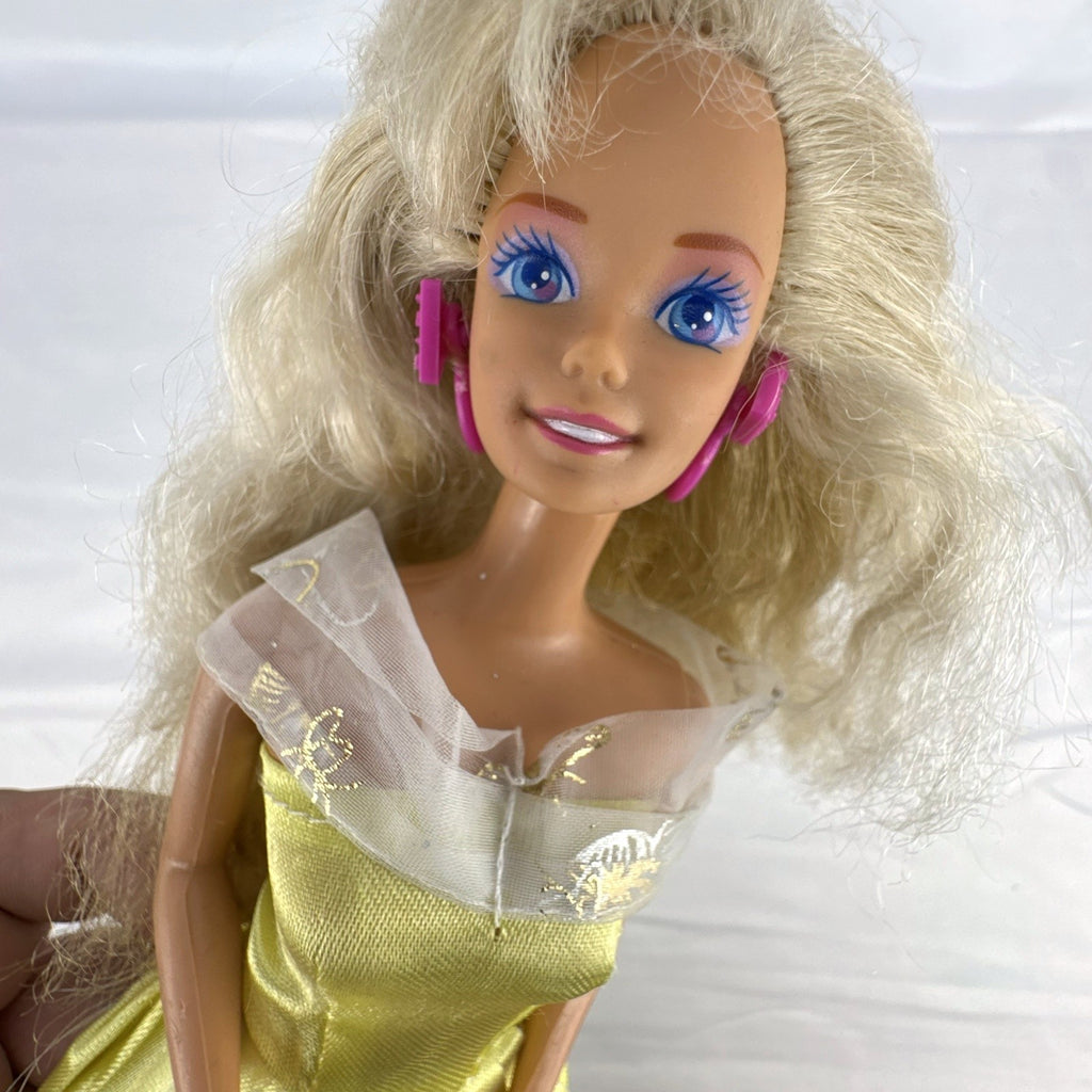 Vintage Mattel Barbie doll wearing yellow butterfly pattern gown with pink earrings
