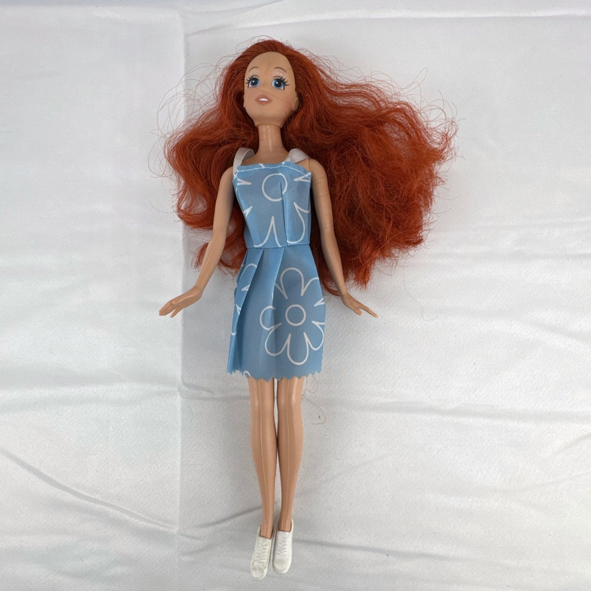 Disney Princess Ariel 11-inch fashion doll with red hair in a blue floral dress and white sneakers
