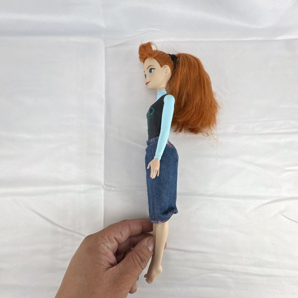 Mattel Disney Frozen 11-inch Princess Anna doll with red hair, molded bodice, and denim skirt.