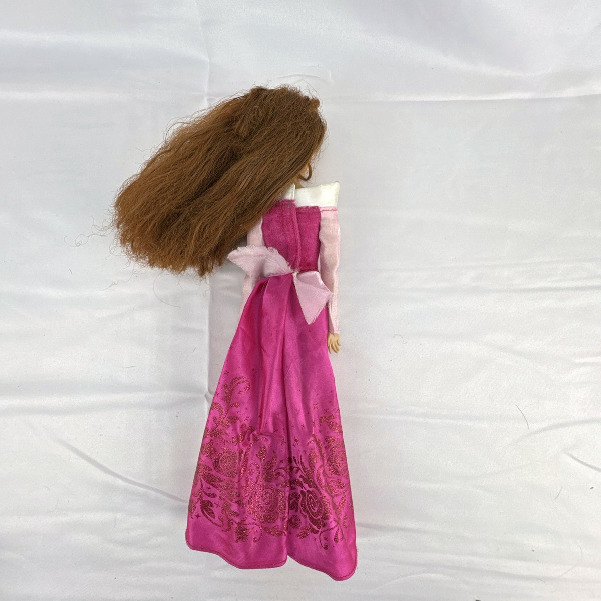 Disney Store 12-inch Belle fashion doll with brown hair wearing a pink and magenta glitter gown