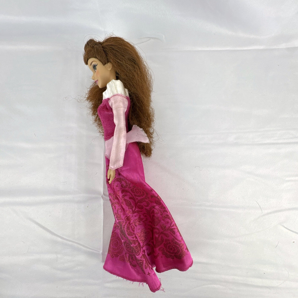 Disney Store 12-inch Belle fashion doll with brown hair wearing a pink and magenta glitter gown