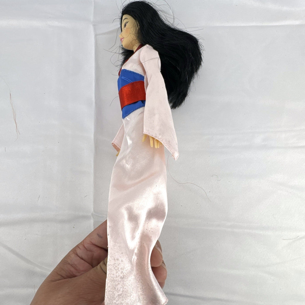 Vintage 12-inch Disney Mulan fashion doll wearing a pink satin matchmaker gown with red and blue sash