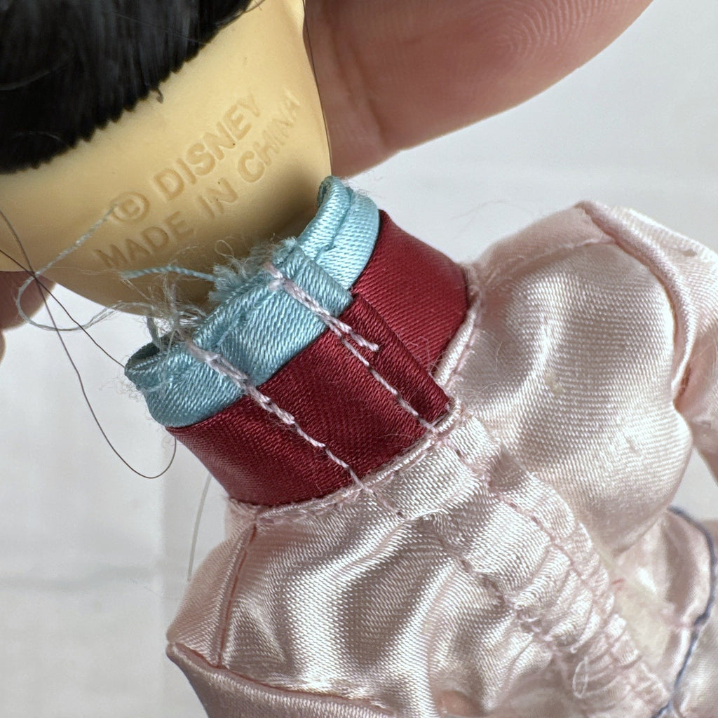 Vintage 12-inch Disney Mulan fashion doll wearing a pink satin matchmaker gown with red and blue sash