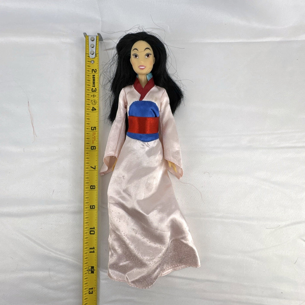 Vintage 12-inch Disney Mulan fashion doll wearing a pink satin matchmaker gown with red and blue sash