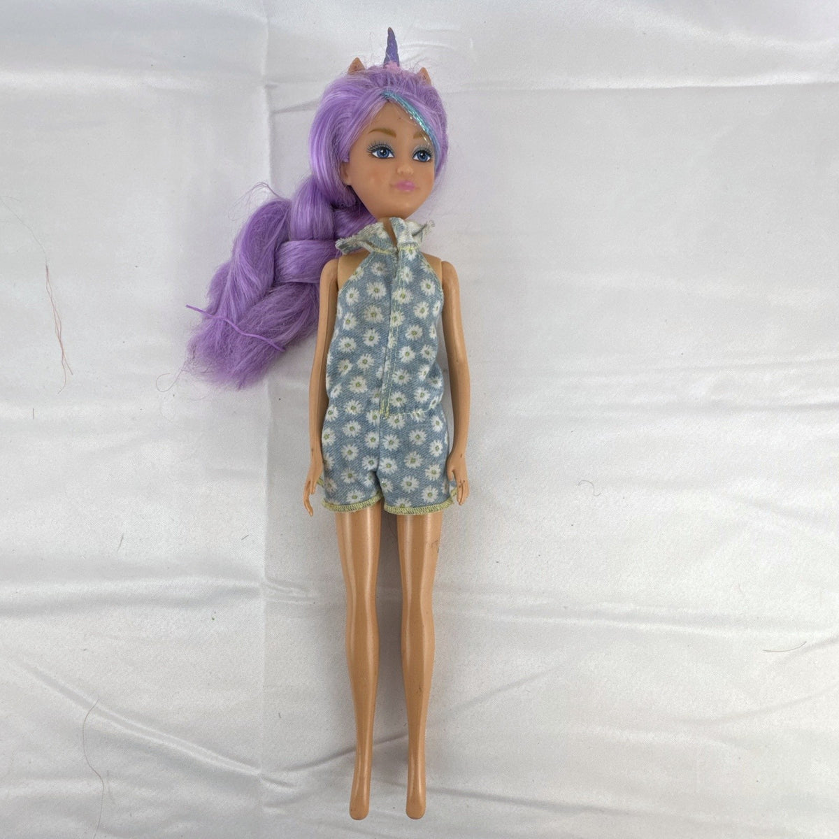 ZURU Sparkle Girlz 10.5-inch unicorn princess doll with purple tinsel hair wearing a blue daisy romper
