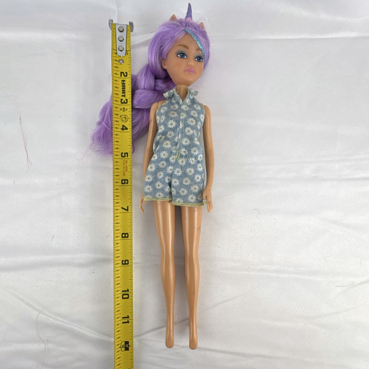 ZURU Sparkle Girlz 10.5-inch unicorn princess doll with purple tinsel hair wearing a blue daisy romper