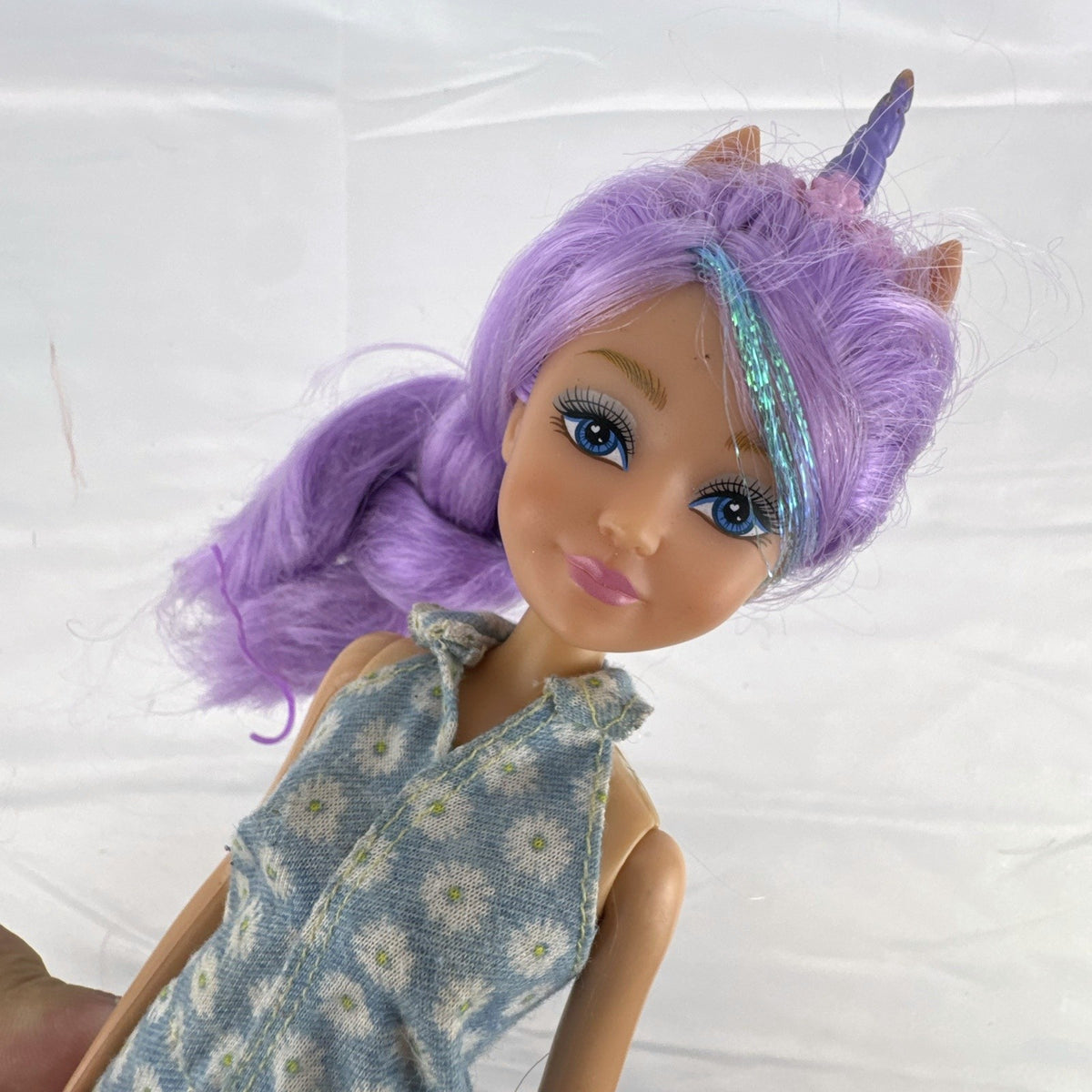 ZURU Sparkle Girlz 10.5-inch unicorn princess doll with purple tinsel hair wearing a blue daisy romper