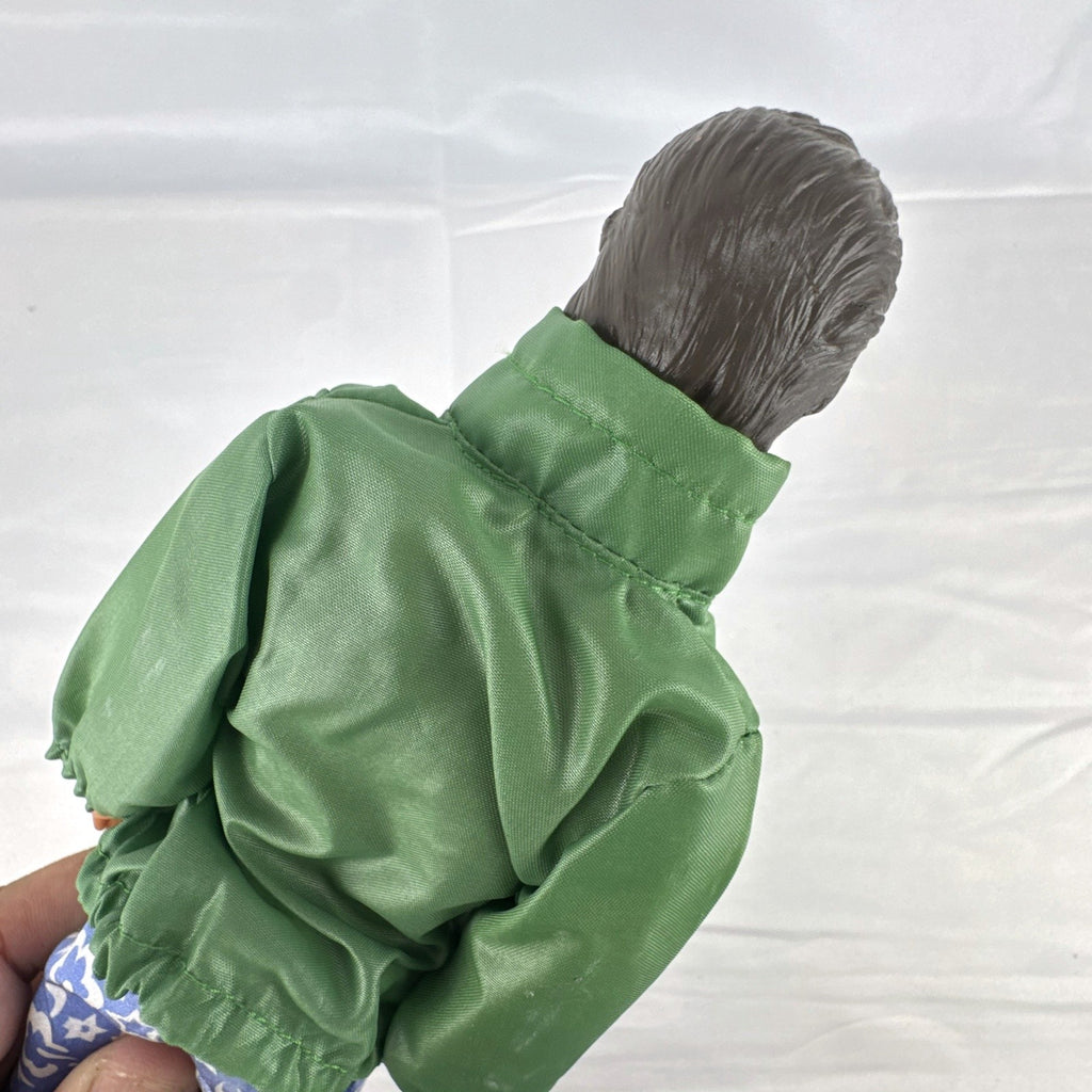 Mattel 12-inch Ken doll with molded brown hair wearing green jacket and blue swim board shorts