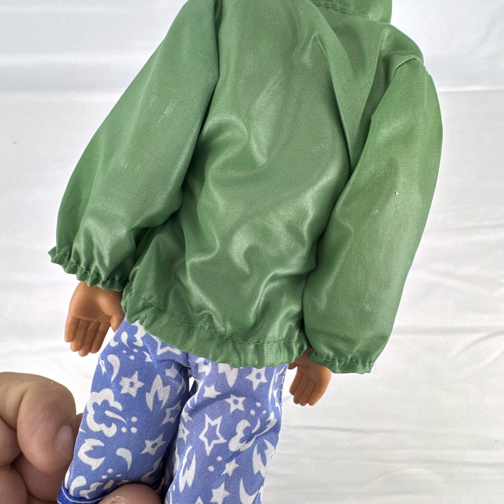 Mattel 12-inch Ken doll with molded brown hair wearing green jacket and blue swim board shorts
