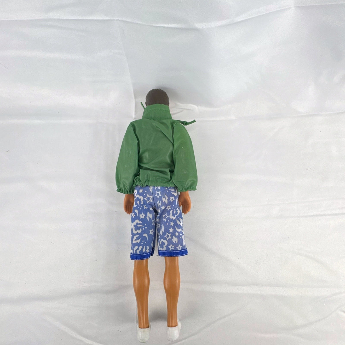 Mattel 12-inch Ken doll with molded brown hair wearing green jacket and blue swim board shorts