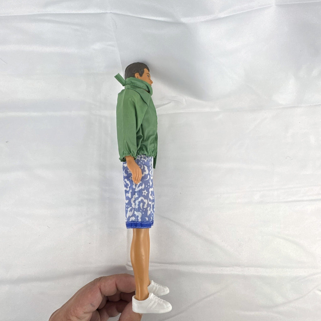 Mattel 12-inch Ken doll with molded brown hair wearing green jacket and blue swim board shorts