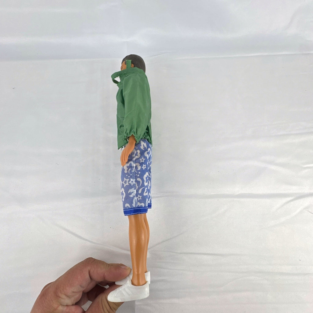 Mattel 12-inch Ken doll with molded brown hair wearing green jacket and blue swim board shorts