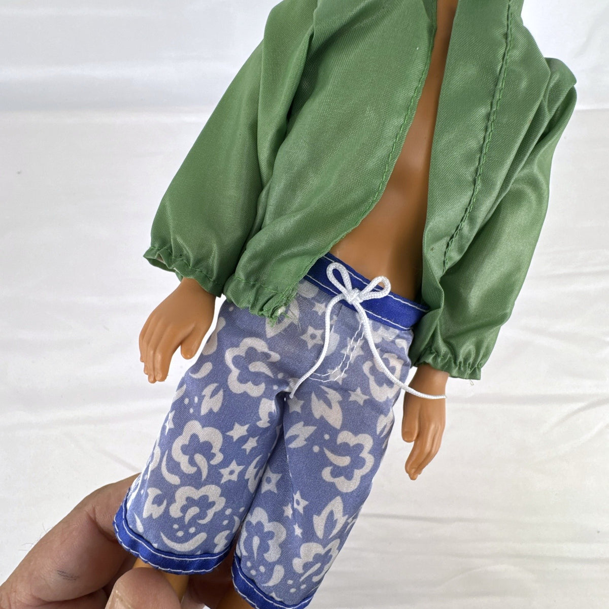 Mattel 12-inch Ken doll with molded brown hair wearing green jacket and blue swim board shorts