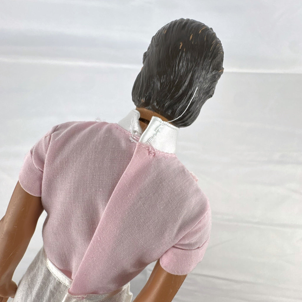 Mattel Barbie Ken 12-inch fashion doll with molded brown hair wearing a pink shirt with suspenders and white pants.