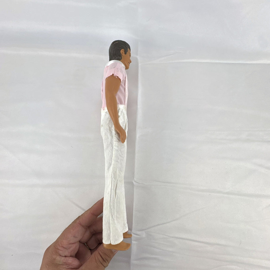 Mattel Barbie Ken 12-inch fashion doll with molded brown hair wearing a pink shirt with suspenders and white pants.