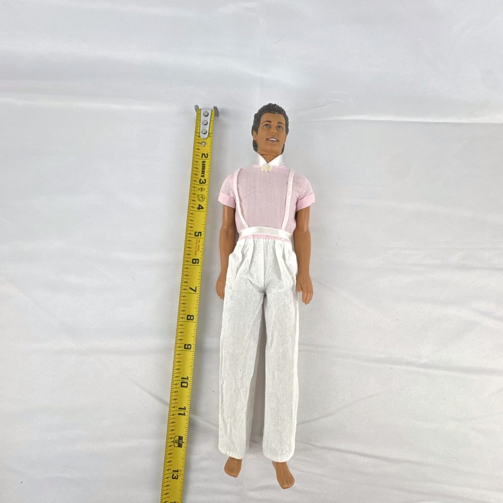 Mattel Barbie Ken 12-inch fashion doll with molded brown hair wearing a pink shirt with suspenders and white pants.