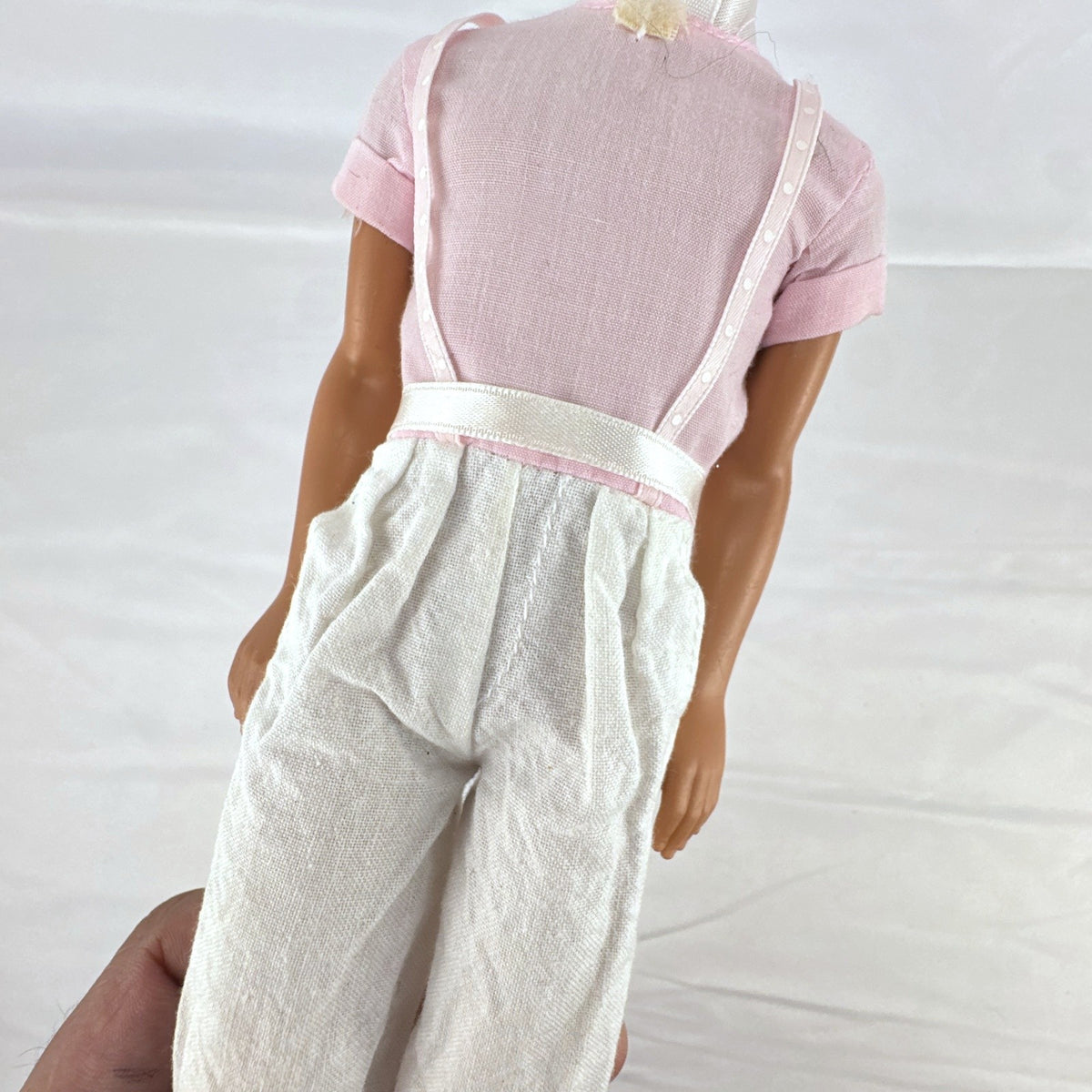 Mattel Barbie Ken 12-inch fashion doll with molded brown hair wearing a pink shirt with suspenders and white pants.