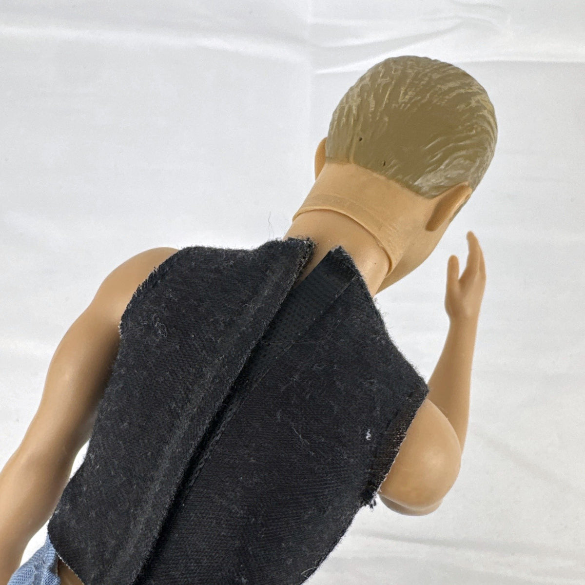 Mattel 12-inch Ken fashion doll with molded blonde hair, blue eyes, graphic sleeveless shirt, and blue trousers