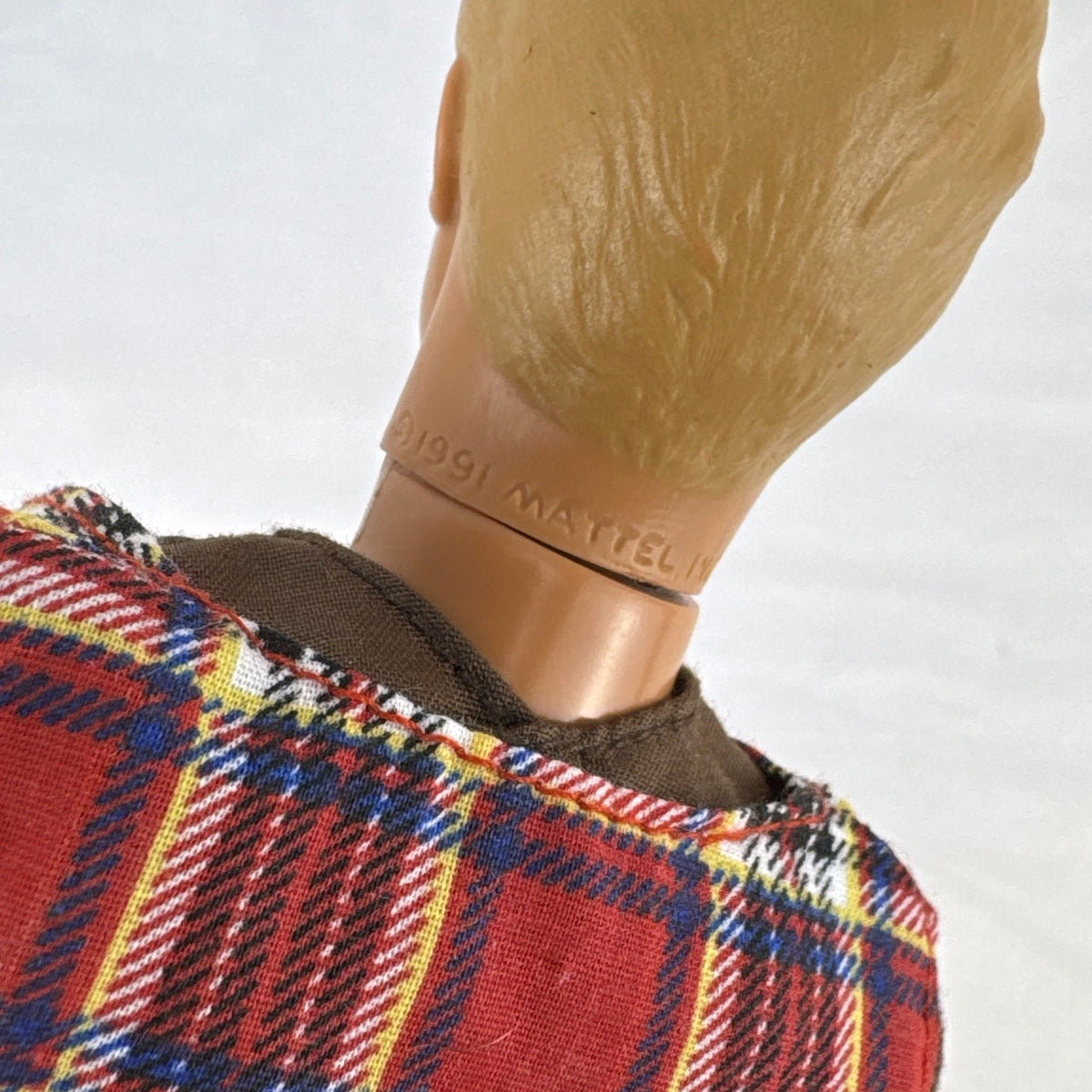Vintage 1991 Mattel Ken doll with molded blonde hair wearing a red plaid vest outfit and brown shoes