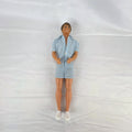Vintage Mattel Ken 12-inch doll with molded brown hair wearing a blue and white striped romper and white shoes.