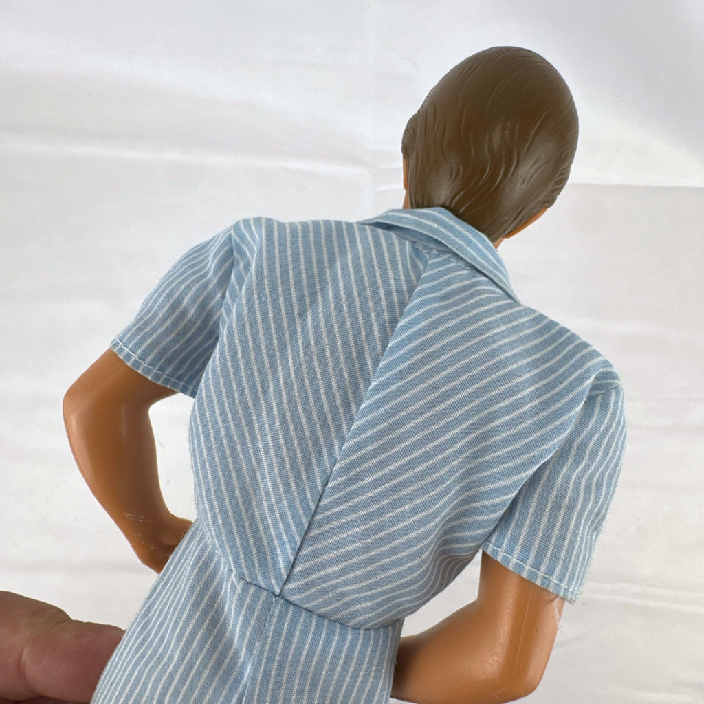 Vintage Mattel Ken 12-inch doll with molded brown hair wearing a blue and white striped romper and white shoes.