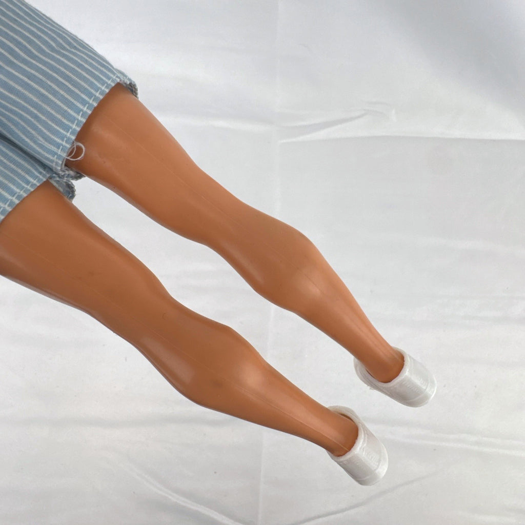 Vintage Mattel Ken 12-inch doll with molded brown hair wearing a blue and white striped romper and white shoes.