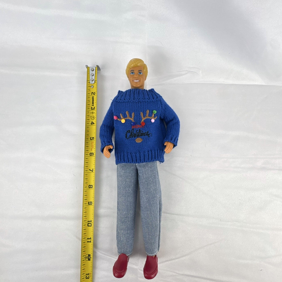 Vintage Mattel Ken doll in blue knit reindeer Christmas sweater, gray pants, and red shoes
