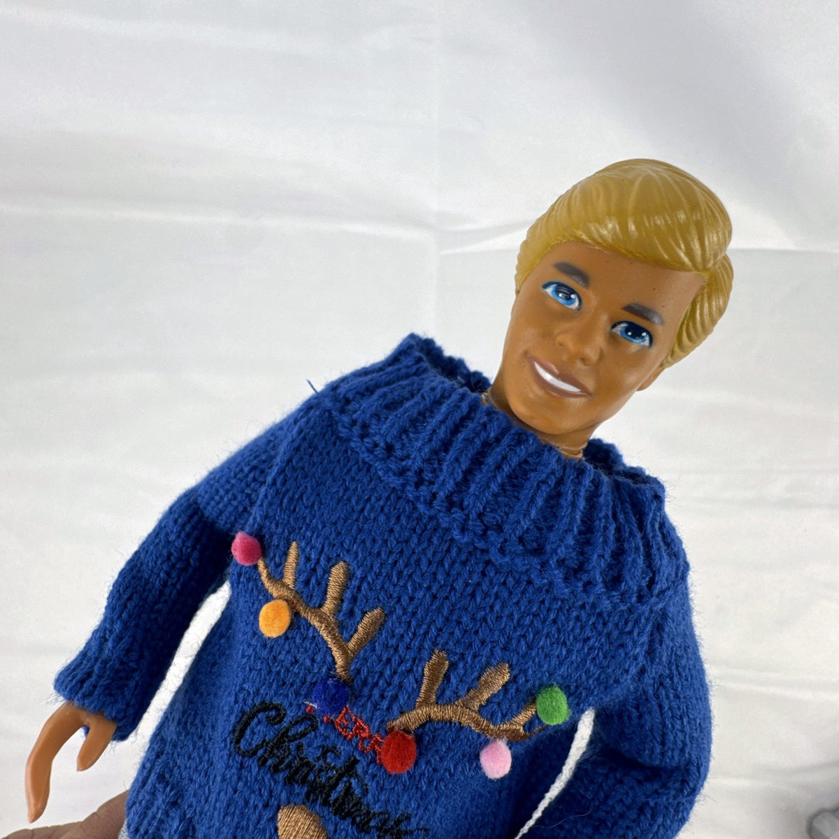 Vintage Mattel Ken doll in blue knit reindeer Christmas sweater, gray pants, and red shoes