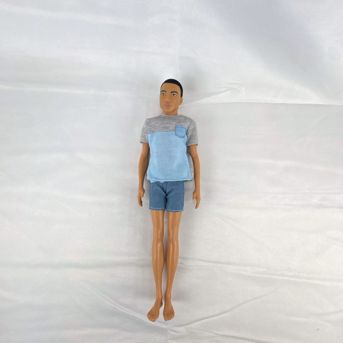 Mattel Ken 12-inch slim fashion doll wearing a colorblock pocket t-shirt and denim shorts