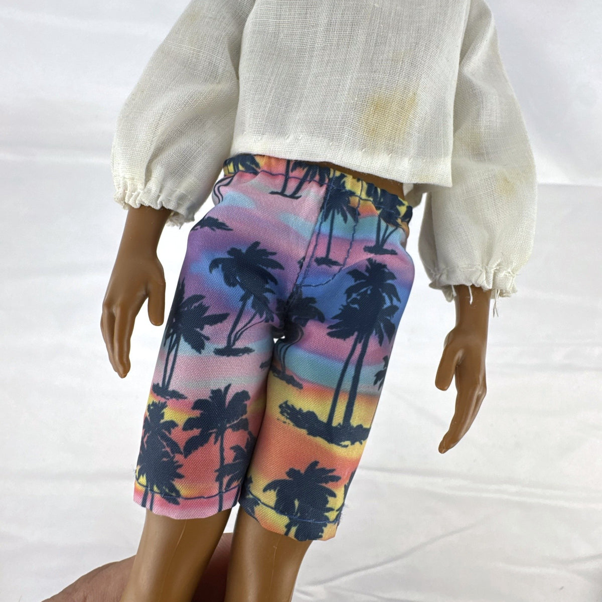 Mattel Barbie Fashionistas 12-inch Ken doll with molded cornrows wearing white mock neck top and palm tree shorts