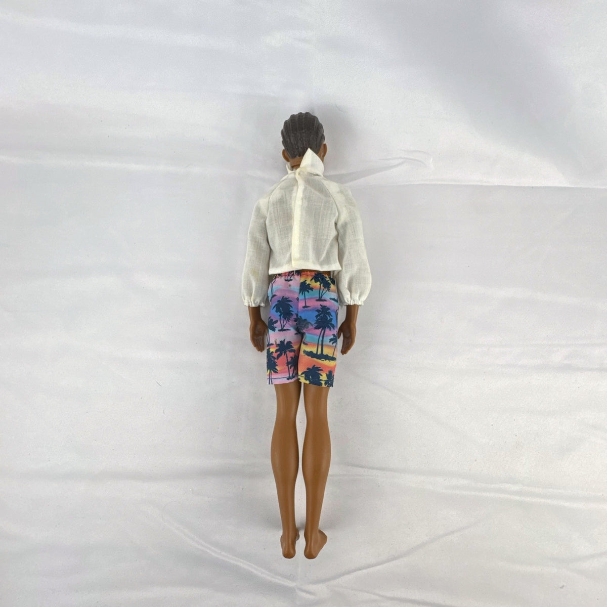Mattel Barbie Fashionistas 12-inch Ken doll with molded cornrows wearing white mock neck top and palm tree shorts