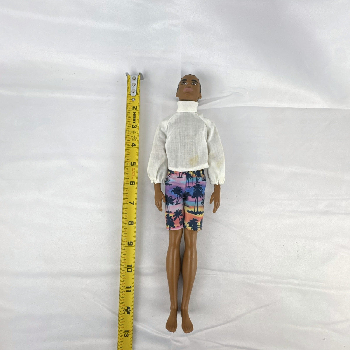 Mattel Barbie Fashionistas 12-inch Ken doll with molded cornrows wearing white mock neck top and palm tree shorts
