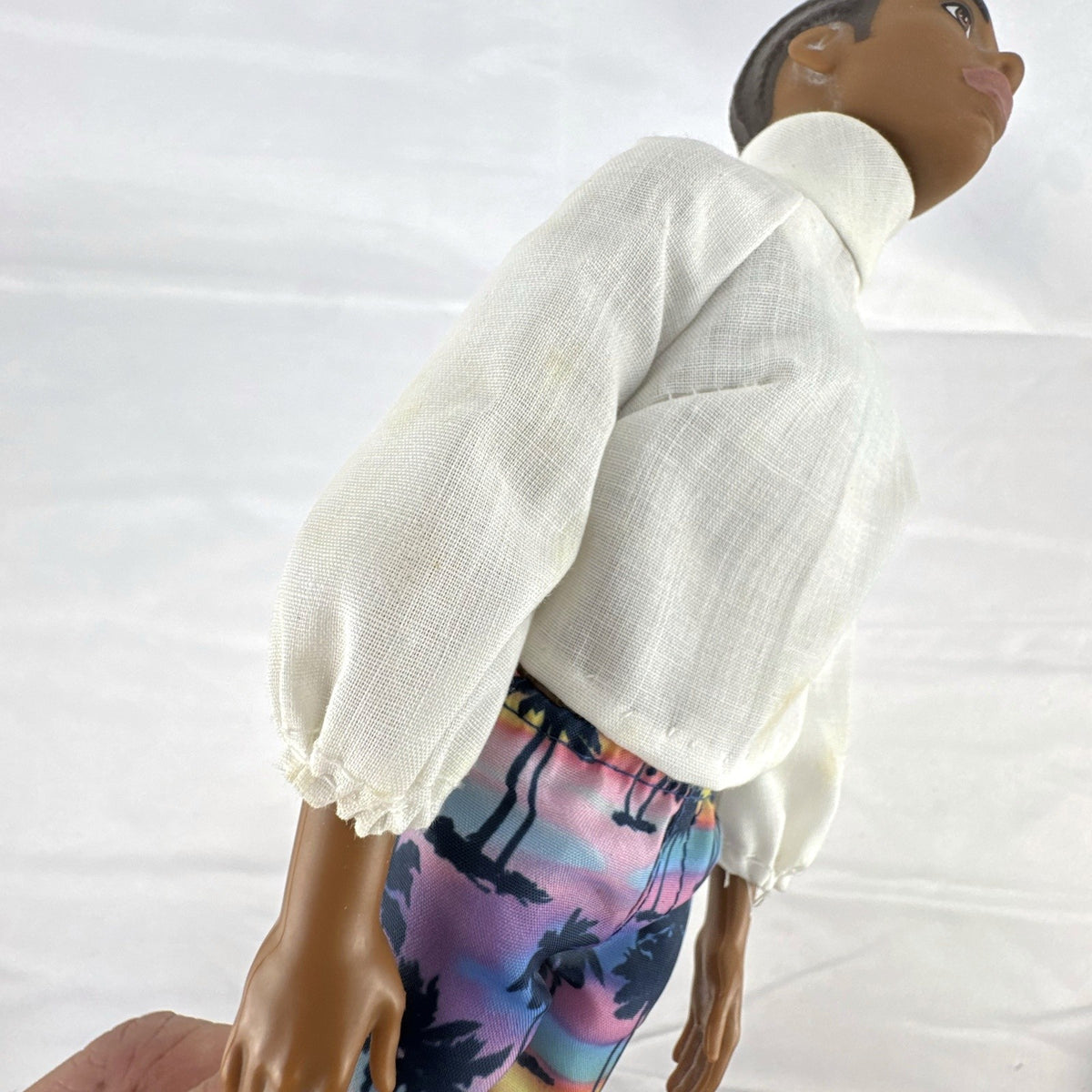 Mattel Barbie Fashionistas 12-inch Ken doll with molded cornrows wearing white mock neck top and palm tree shorts