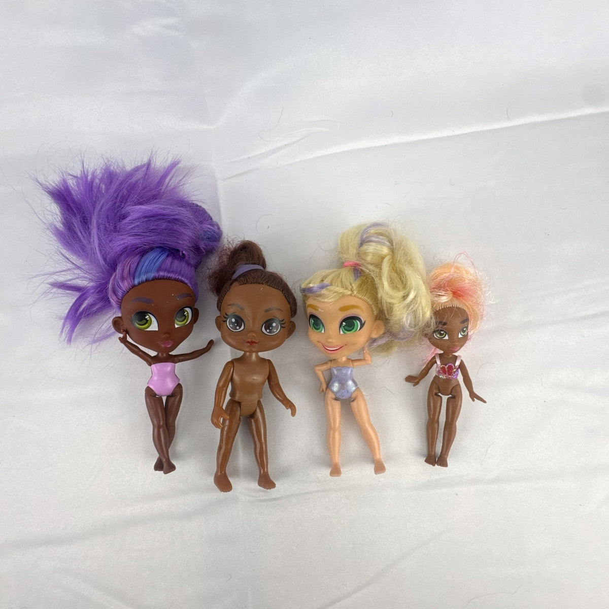 Four Just Play Hairdorables and Shortcuts mini fashion figures with colorful rooted hair