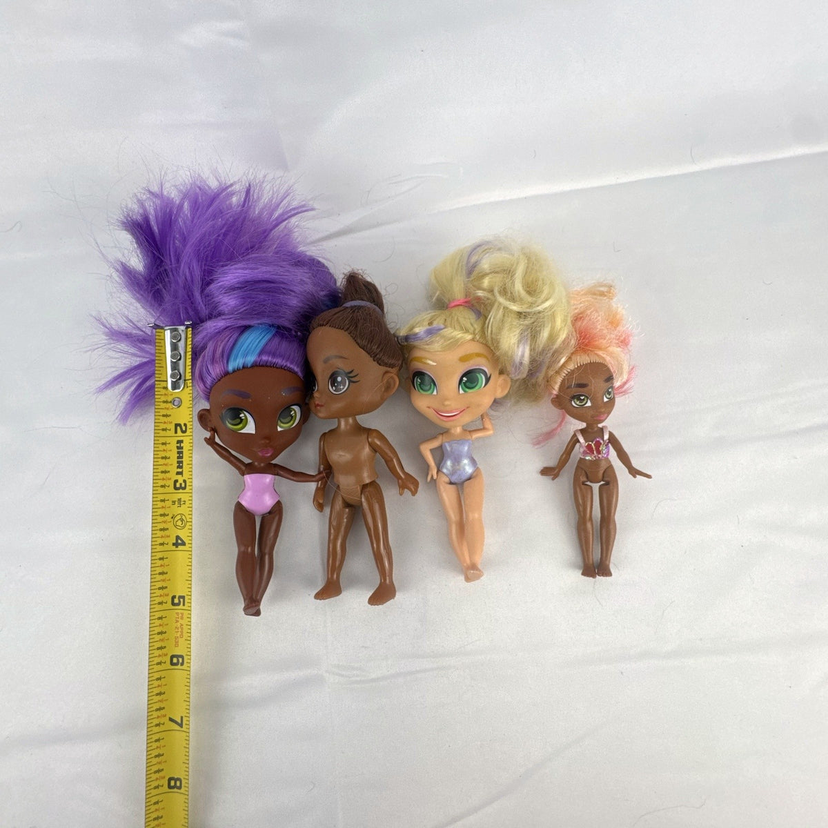 Four Just Play Hairdorables and Shortcuts mini fashion figures with colorful rooted hair