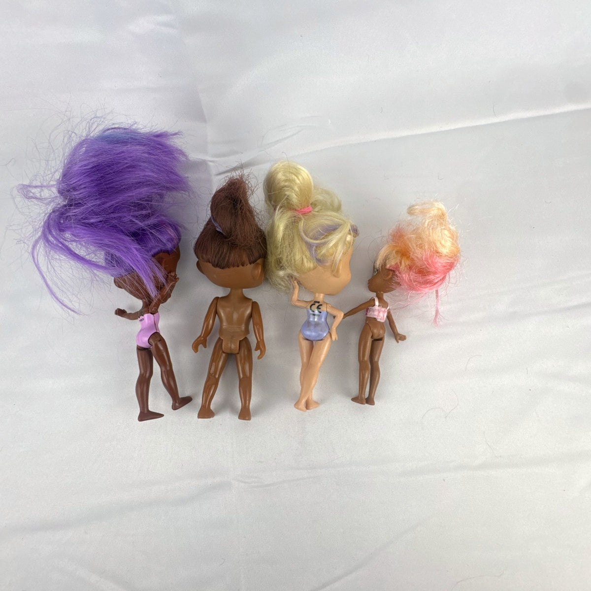 Four Just Play Hairdorables and Shortcuts mini fashion figures with colorful rooted hair