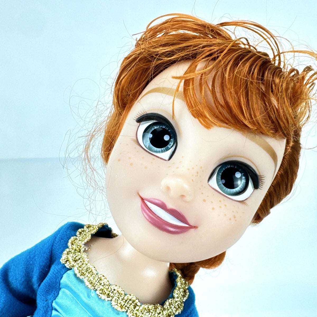 Disney Frozen 13-inch toddler Anna doll wearing blue dress and green pom-pom shoes