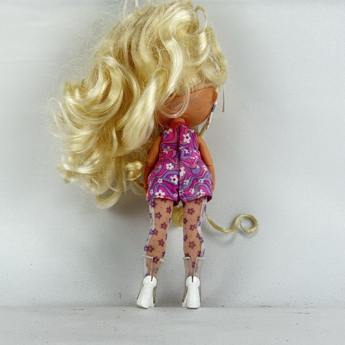 MGA L.O.L. Surprise Tweens Series 2 Goldie Twist doll wearing floral outfit, tights, and clear boots