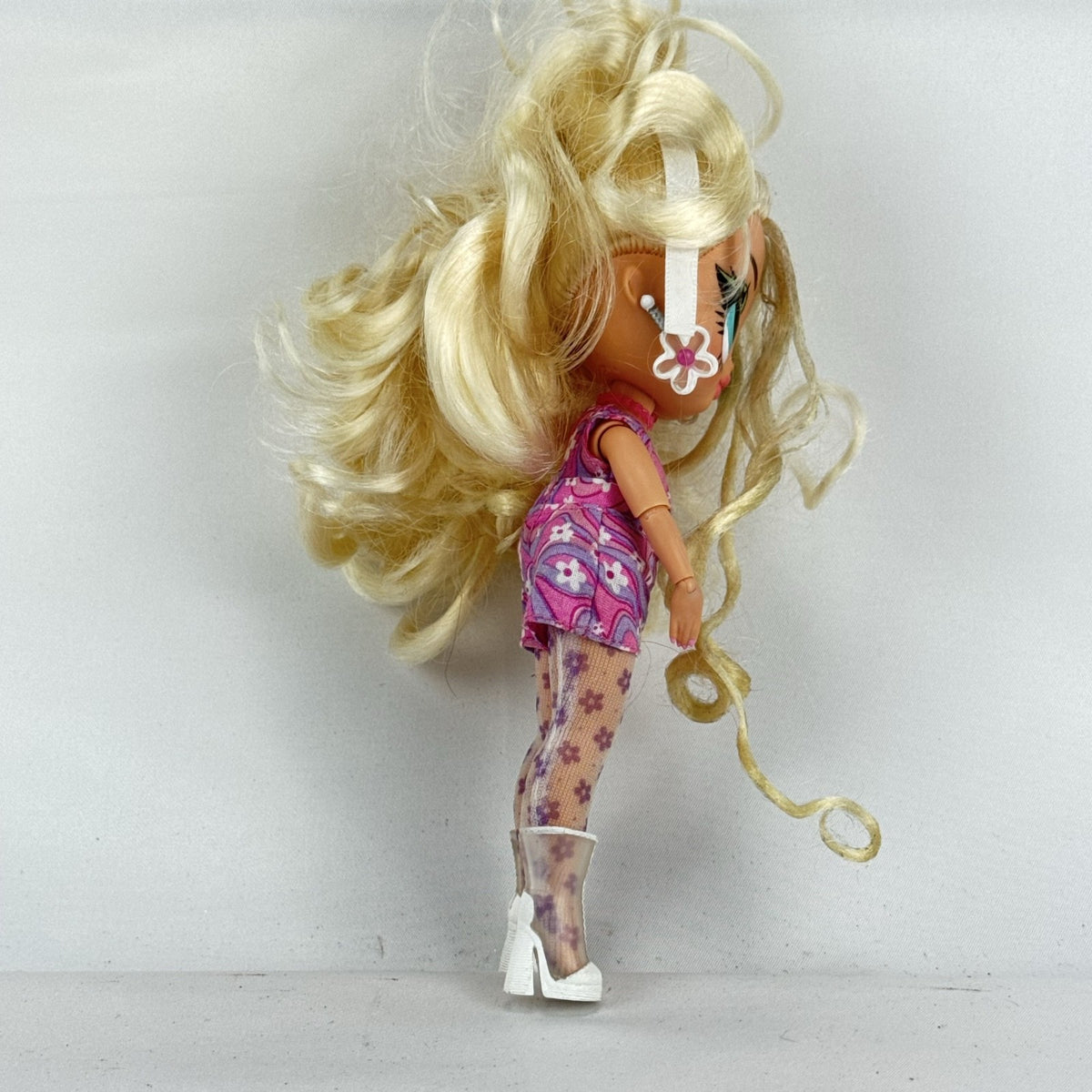 MGA L.O.L. Surprise Tweens Series 2 Goldie Twist doll wearing floral outfit, tights, and clear boots