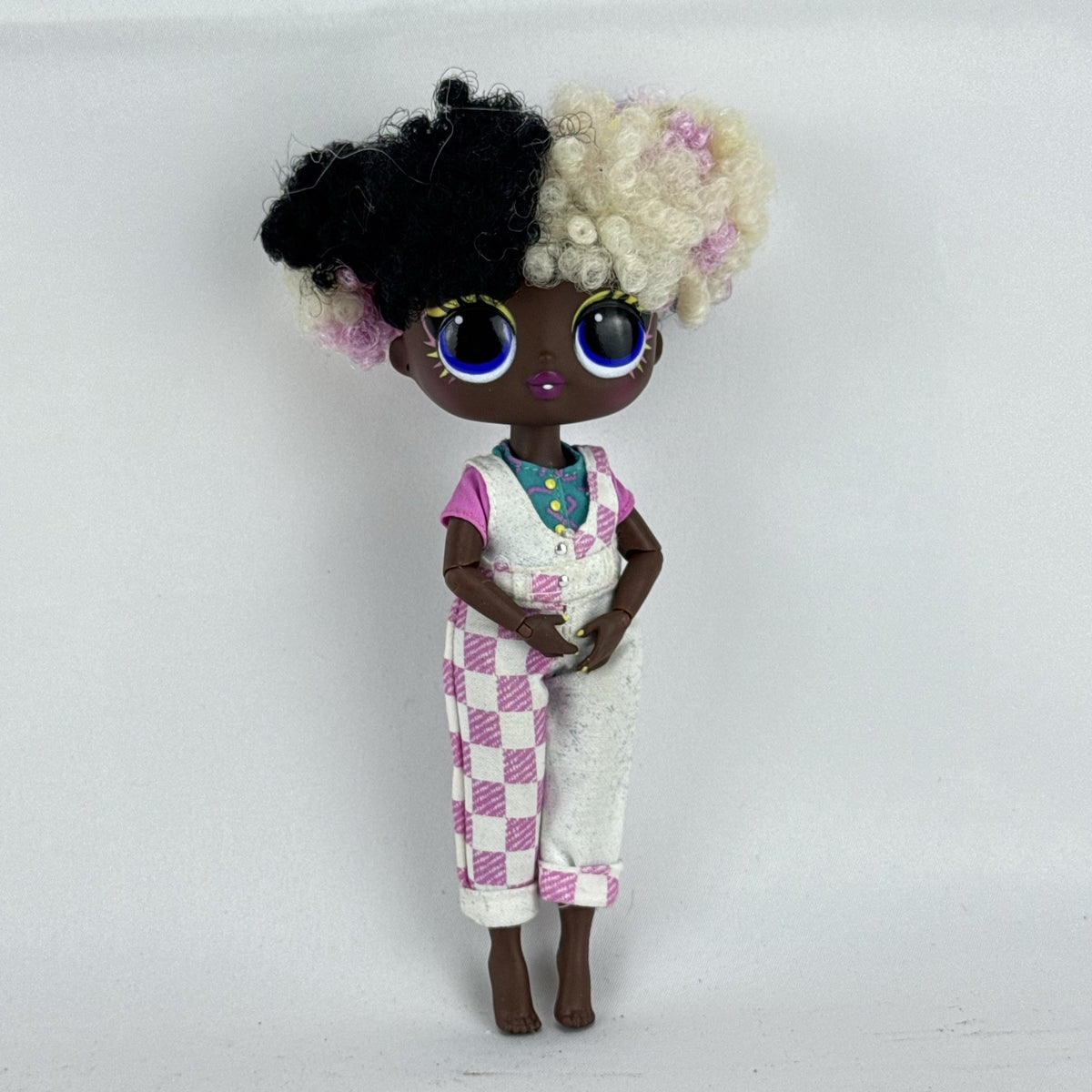 MGA LOL Surprise Tweens Winnie fashion doll in split checkered overalls with two-tone curly afro puff buns.