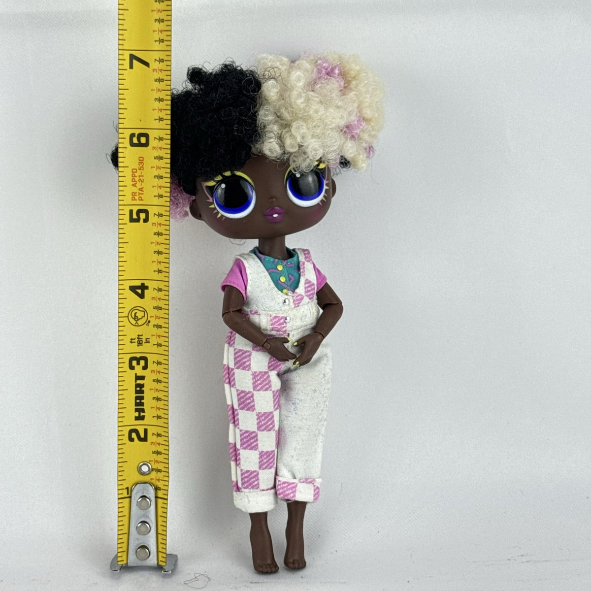 MGA LOL Surprise Tweens Winnie fashion doll in split checkered overalls with two-tone curly afro puff buns.
